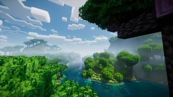 Green treetops surrounding a winding river in a misty Minecraft landscape